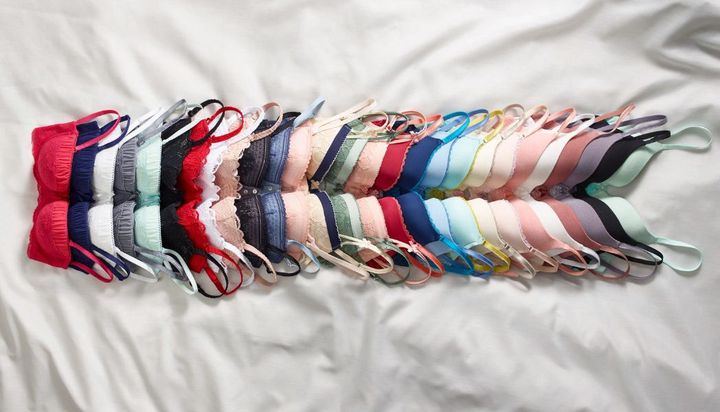 A collection of bras in various colors laid out in rows.