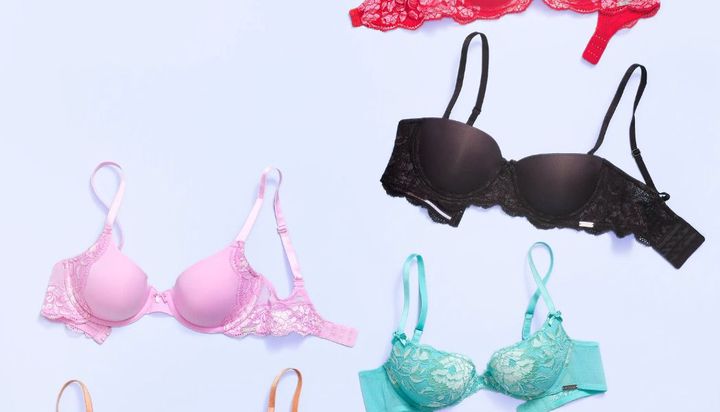 Four bras of different colors are arranged on a light blue background.