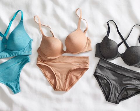 Three sets of bras and underwear in blue, nude, and gray.