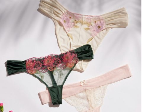 Three pairs of women's lace thong underwear in white, green, and pink.