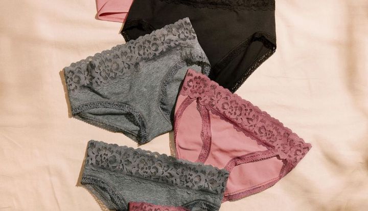 Assortment of women's lace-trim underwear in black, pink, and gray.
