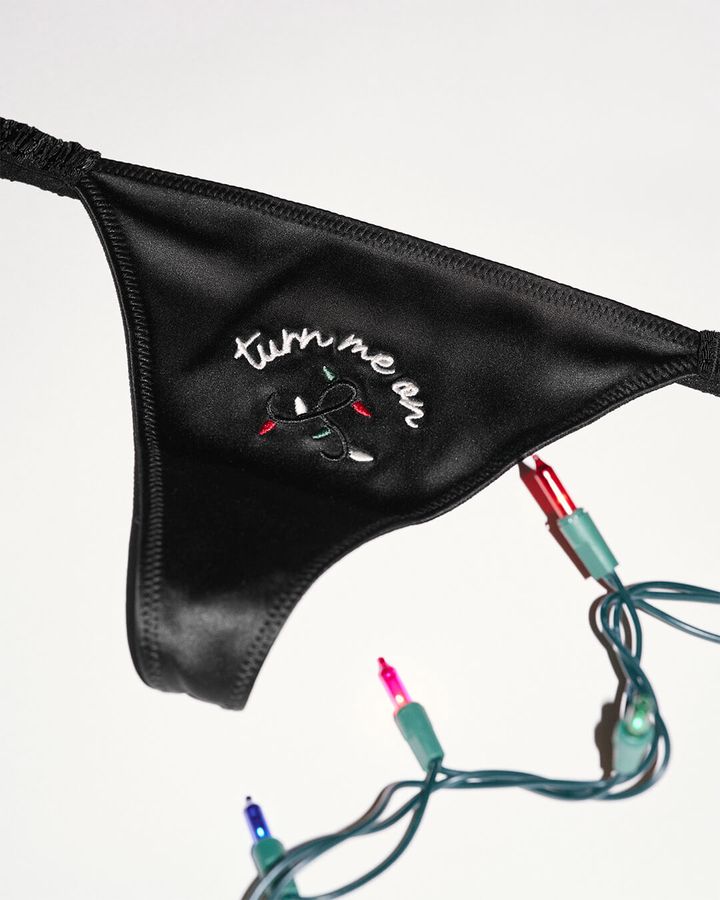 Black silk thong with "turn me on" embroidery and Christmas lights.