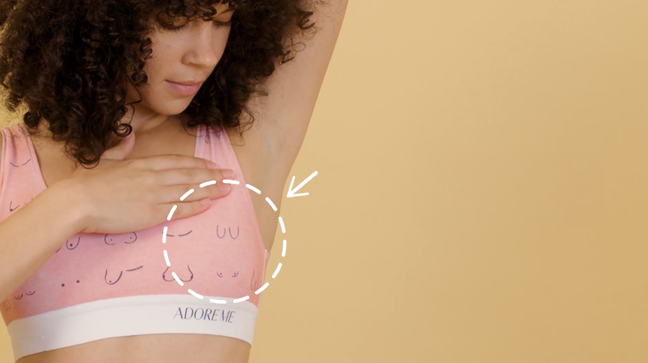 Woman in pink "boob print" bralette, with an arrow pointing to her underarm.