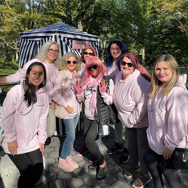 Group in pink hoodies with boob graphics promotes "Free Bra Fittings.