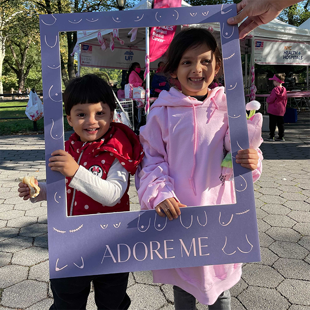 Two children in a frame with "ADORE ME" text and breast icons.