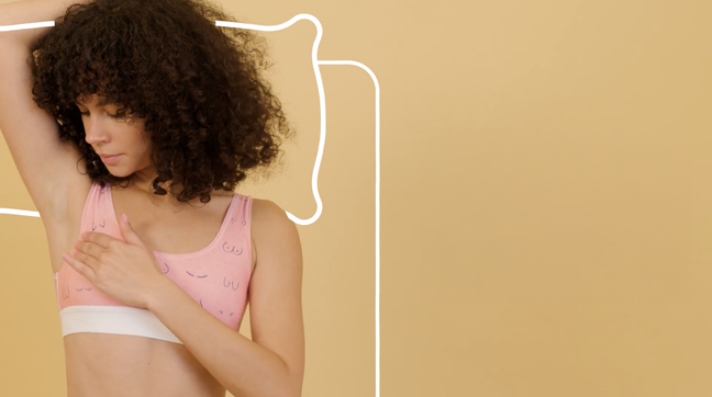 Woman in a bra checking her armpit for breast cancer.