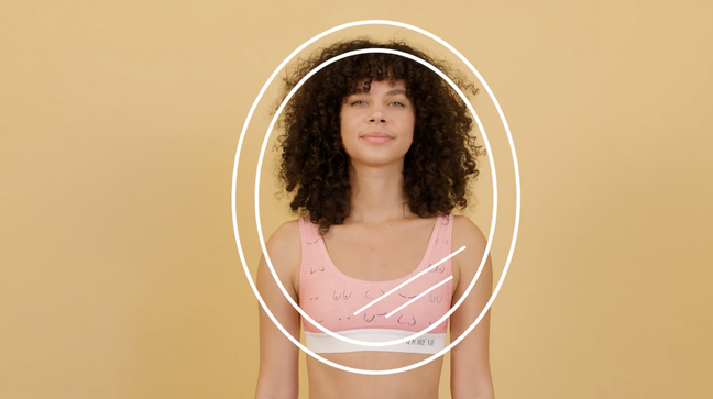 Woman in a pink bralette with breast illustrations.