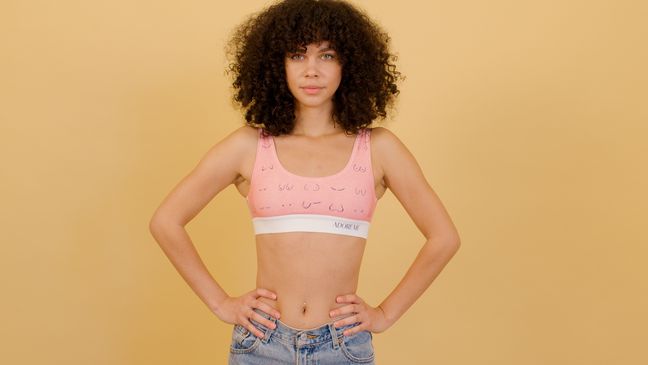 Woman in a pink Adore Me bralette with breast illustrations.